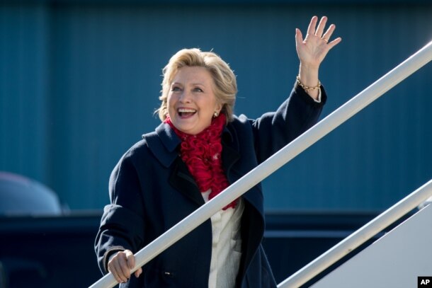 Democratic presidential candidate Hillary Clinton waves to members of the media as she boards her campaign plane at Westchester County Airport in White Plains, New York, Nov. 1, 2016, to travel to Florida for rallies.
