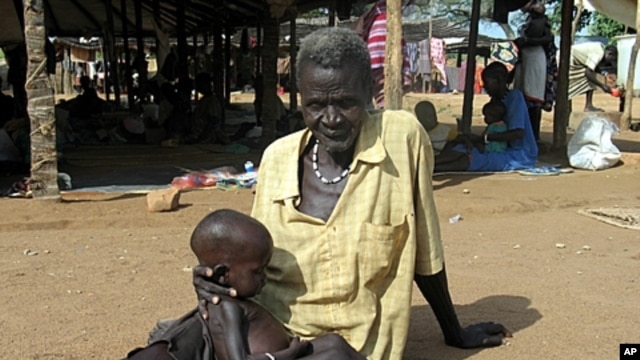 Sudanese man holds malnourished grandson at Medicine Sans Frontieres feeding center, Sept. 2005 (file photo).