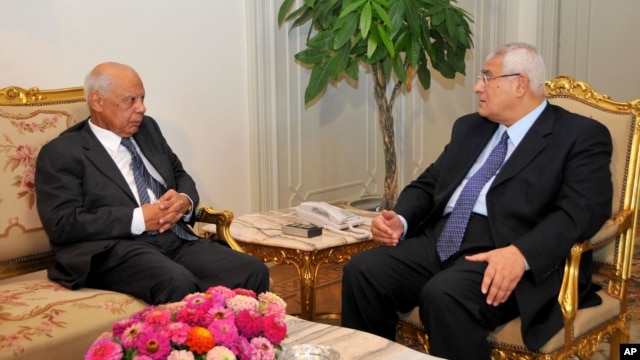 Presiden sementara Mesir Adly Mansour (kanan) berbicara dengan PM sementaar, Hazem el-Beblawi di Kairo (9/7). Pemerintah baru Mesir mendapatkan janji bantuan hibah 8 milyar dolar dari Arab Saudi dan UEA. 