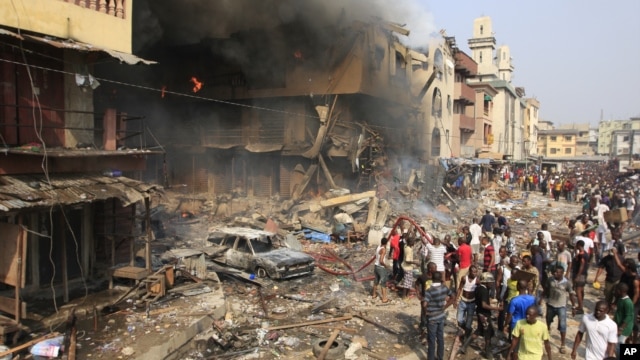 People gather at the site of a fire, a result of an explosion at a warehouse where witnesses say fireworks were stored, December 26, 2012. 