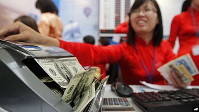A Vietinbank employee counts US dollars at a currency exchange counter at the National Convention Center, the venue for the 44th annual meeting of Asian Development Bank (ADB), in Hanoi, May 5, 2011.