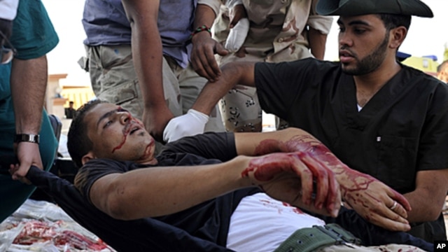Libyan revolutionary fighters transport an injured man to a field hospital outside Sirte, Libya, September 30, 2011.