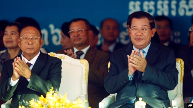 Cambodian Prime Minister Hun Sen, front right, applauds together with the National Assembly President Heng Samrin, front left, during an event by the ruling Cambodian People's Party marking the 36th anniversary of the 1979 downfall of the Khmer Rouge regi