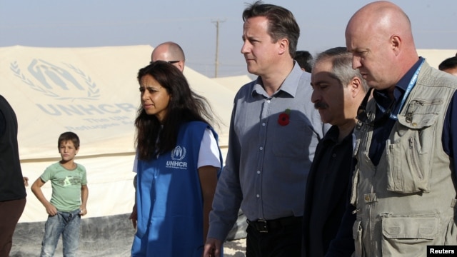 Britain's PMr David Cameron walks with Jordanian Foreign Minister Nasser Judeh and UNHCR representative to Jordan Andrew Harper during his visit to Al-Zaatri refugee camp in the Jordanian city of Mafraq, November 7, 2012.  