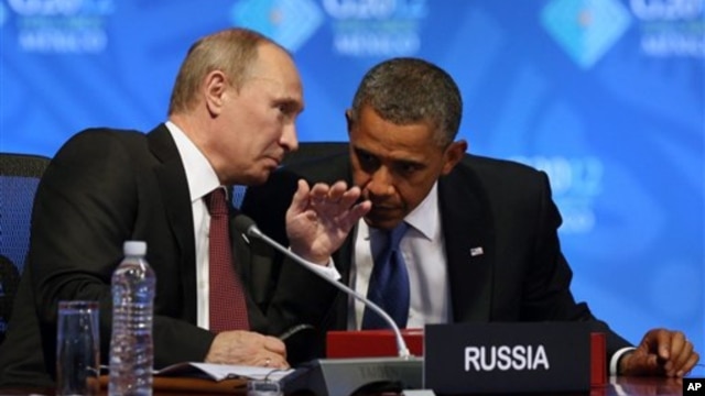 U.S. President Barack Obama (R) listens to Russia's President Vladimir Putin before the opening of the first plenary session of the G-20 Summit in Los Cabos, Mexico, June 18, 2012.