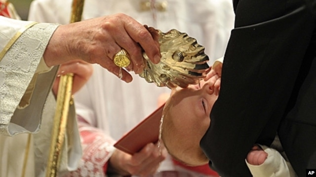 Pope Benedict XVI baptizes one of 21 newborns during in the Sistine Chapel, the Vatican, Jan. 9, 2011 (file photo).