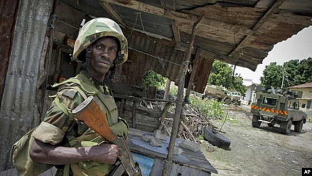 A Ugandan soldier serving with the African Union Mission in Somalia stands guard during the removal of a haul of 155mm artillery shells that were found in a house deep inside a former al-Shabab stronghold in the Somali capital Mogadishu, August 12, 2011