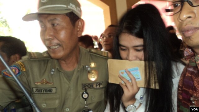 Kahiyang Ayu, daughter of Indonesian President Joko Widodo, is escorted by security as she arrives to take the civil service exam in the city of Solo, Central Java, Oct. 23, 2014. (Y. Satriawan / VOA)