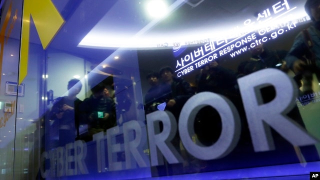 Members of media are reflected on the door of Cyber Terror Response Center as they wait to enter the lab at National Police Agency in Seoul, South Korea, March 21, 2013.