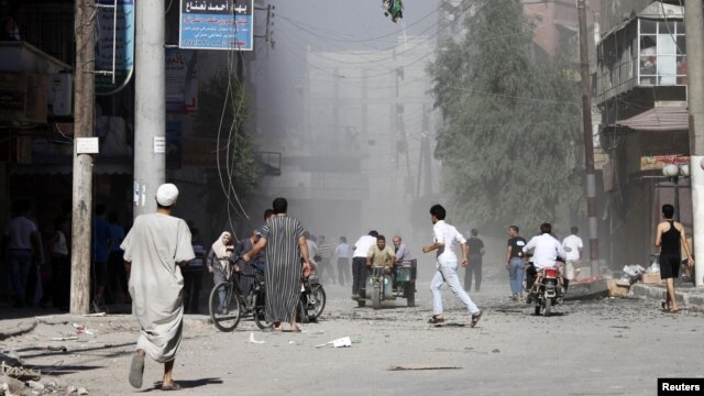 Cư dân bỏ chạy vì pháo kích trên đường phố ở thị trấn Aleppo của thành phố al-Shaar, ngày 16/9/2012