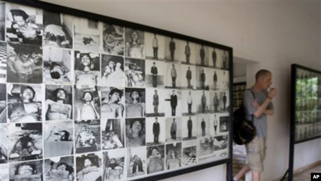 A tourist walks past photos of former prisoners displayed at Tuol Sleng genocide museum, a former Khmer Rouge prison known as S-21, in Phnom Penh.