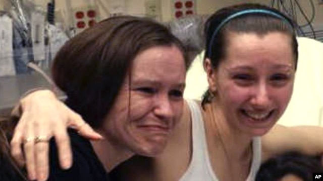 Amanda Berry, right, hugs her sister Beth Serrano after being reunited in a Cleveland hospital Monday May 6, 2013.