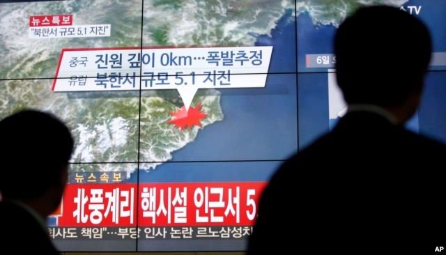 FILE - People walk by a screen showing the news reporting about an earthquake near North Korea's nuclear facility, in Seoul, South Korea, Jan. 6, 2016.