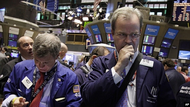 Traders Richard Newman, left, and David O'Day work on the floor of the New York Stock Exchange, June 14, 2011 (file photo)