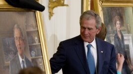 Former President George W. Bush and former first lady Laura Bush, right, unveil their portraits in the East Room of the White House in Washington, Thursday, May 31, 2012