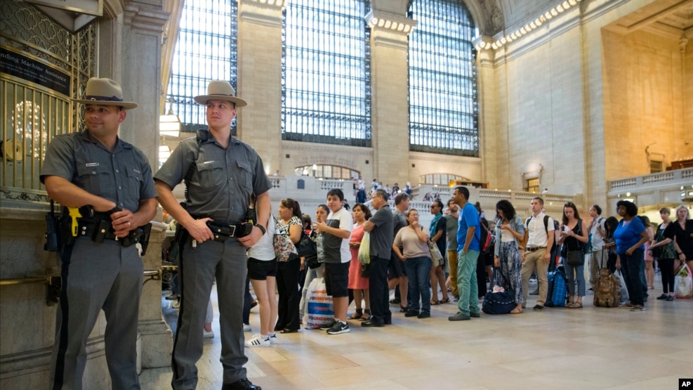 Cảnh sát đứng bảo vệ trong khi người dân xếp hàng mua vé tàu tại Nhà ga Trung tâm ở New York, ngày 1 tháng 7 năm 2016.