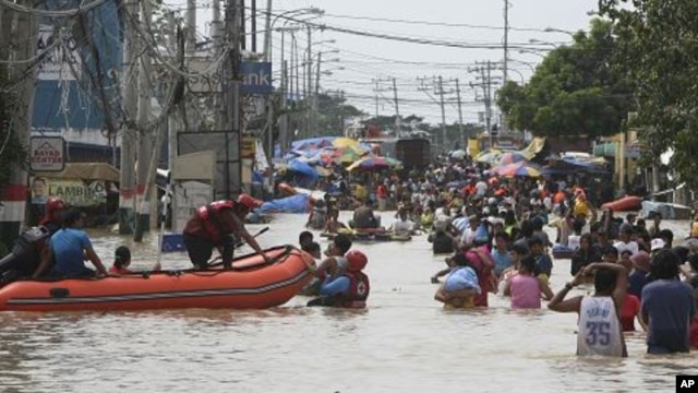 Residents wade through floodwaters as flooding continues for the fourth day at Calumpit township, Bulacan province north of Manila, Philippines, October 2, 2011.