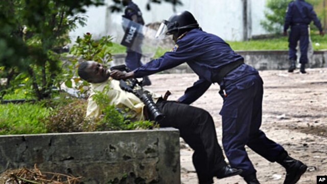 A supporter of Congolese opposition leader Etienne Tshisekedi is grabbed by a Congolese riot police officer outside his candidate's headquarters in Kinshasa, Democratic Republic of Congo, December 8, 2011