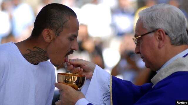 Un pandillero recibe la comunión en una cárcel salvadoreño, luego de alcanzar un acuerdo entre pandillas rivales y el gobierno para disminuir el número de homicidios en El Salvador.