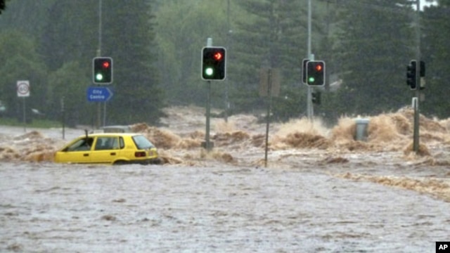 A passenger in a car waves for assistance as a flash flood sweeps across an intersection in Toowoomba, 105 km (65 miles) west of Brisbane, Australia, 10 Jan 2011
