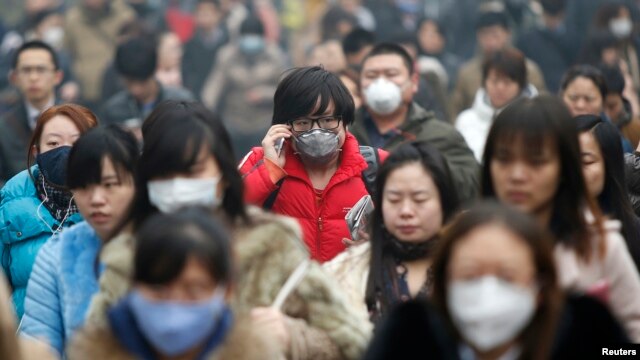 Peatones usando máscaras para protegerse de la contaminación en Beijín. El crecimiento poblacional debe tener un límite dicen las autoridades de la ciudad.