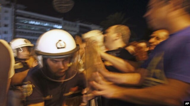 Anti-austerity protesters push police officers outside the Greek parliament following an unscheduled cabinet meeting by Greek Prime Minister George Papandreou to decide on more austerity measures to secure continued funding under an international bailout,