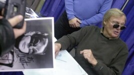 Adam West, who played Batman on TV in the 1960s, with a fan in 2002