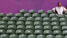 A spectator sits amid empty seats at the All England Lawn Tennis Club during a match at the London 2012 Olympics Games July 28, 2012. 