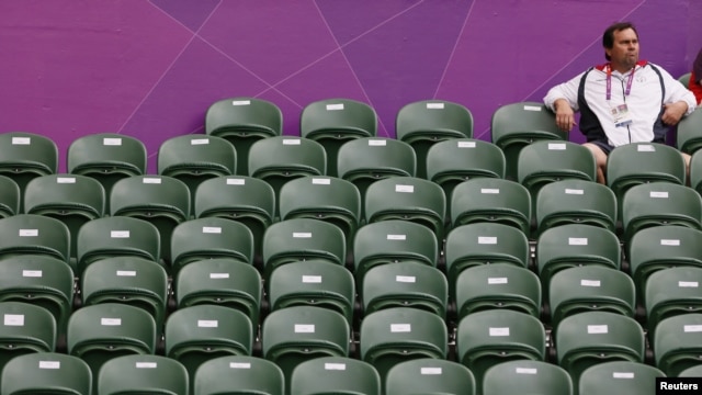 A spectator sits amid empty seats at the All England Lawn Tennis Club during a match at the London 2012 Olympics Games July 28, 2012. 