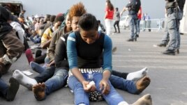 Migrants rest after disembarking from the British assault ship HMS Bulwark at the Sicilian port of Catania after being rescued at sea, Italy, June 8, 2015.