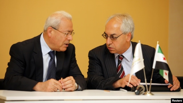 The new president of the Syrian National Council Abdelbaset Seida (R) talks with former President Burhan Ghalioun before a news conference in Istanbul, June 10, 2012.