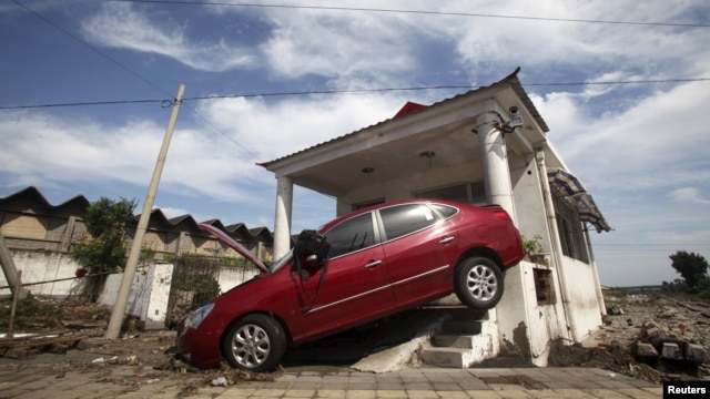 A car damaged by floods is seen after heavy rainfalls hit Zhou Kou Dian Village, Fangshan district, near Beijing, China, July 22, 2012. 