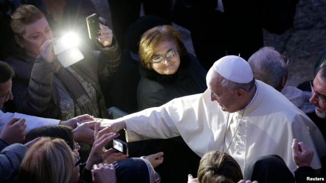 FILE - Pope Francis greets the faithful as he arrives to visit the Church of St Alfonso Maria dei Liguori in the outskirts of Rome, Jan. 6, 2014.