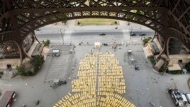 Thousands of people performed yoga on yellow mats at the Eiffel Tower in Paris Sunday.