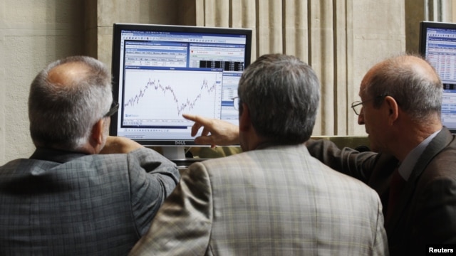Traders look at a computer screen at the Madrid Bourse, July 24, 2012. 