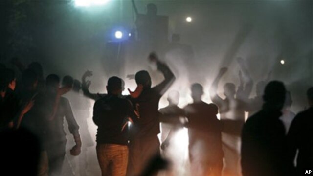Egyptian voters protest in front of a anti-riot vehicle as they claim they were prevented from casting their votes in Damas, near El Dakahlia, Egypt, 05 Dec 2010