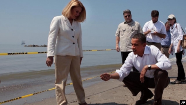 President Barack Obama and Lafourche Parish President Charlotte Randolf, left, inspect a tar ball as they look at the effect the BP oil spill is having on Fourchon Beach in Port Fourchon, Louisiana, May 28, 2010. (Official White House Photo by Chuck Kenne