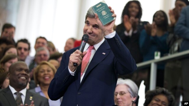 El nuevo secretario de Estado John Kerry muestra su recién adquirido pasaporte diplomático en una reunión con el personal del Departamento de Estado.