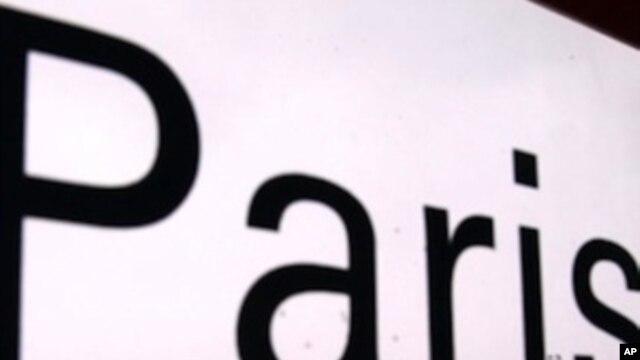 The word Paris is displayed on a window at the Charles de Gaulle airport as Air France sit outside covered in snow and ice.