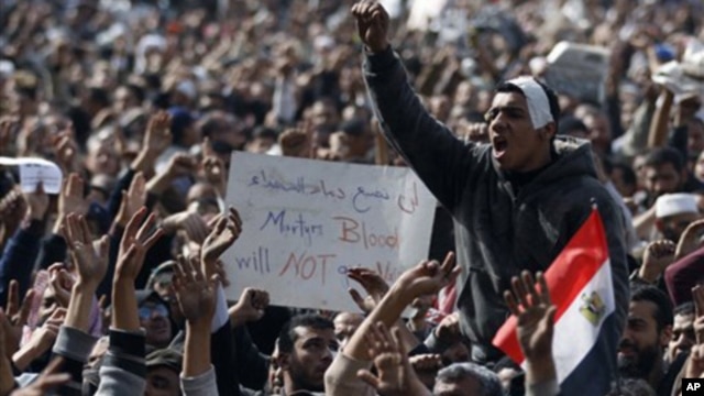 Anti-government protesters react in Tahrir Square, Cairo, Egypt, Friday, Feb. 4, 2011