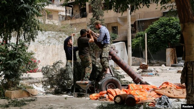 Thành viên của nhóm phiến quân Hồi giáo al-Nusra Front chuẩn bị súng cối tự chế trong khu vực Bustan al-Qasr của thành phố Aleppo, Syria.