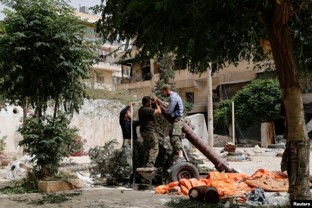 FILE - Members of the Islamist rebel group al-Nusra Front prepare a homemade mortar in the Bustan al-Qasr neighborhood of Aleppo, Syria, June 5, 2014.