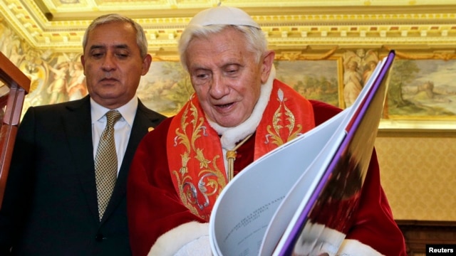 Pope Benedict XVI exchanges gifts with Guatemala's President Otto Perez Molina during a private audience at the Vatican February 16, 2013.