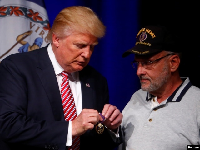 Republican U.S. Presidential nominee Donald Trump talks to Lt. Col. Louis Dorfman, who gave Trump his Purple Heart, during a campaign event at Briar Woods High School in Ashburn, Virginia, Aug. 2, 2016.