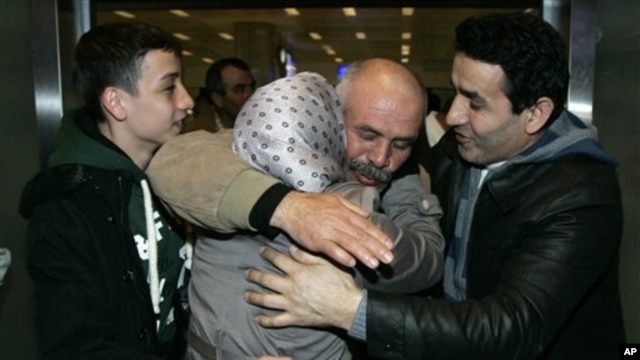A Turkish man, second from right, greets family members after arriving in Turkey from Libya February 22, 2011.