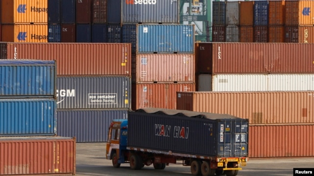A truck ferries a shipping container at a port in the southern Indian city of Chennai, February 13, 2013.