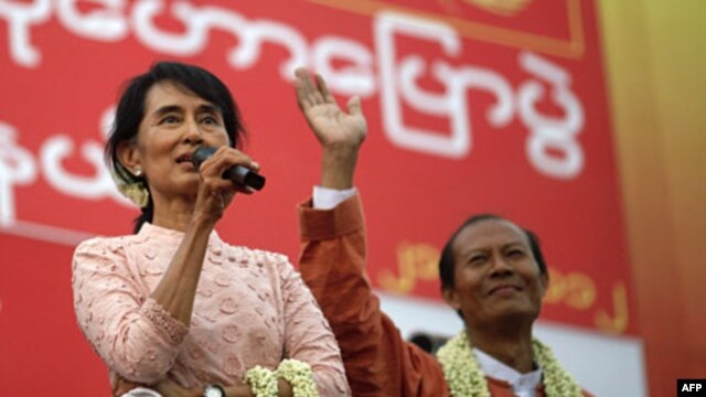 Burma's Aung San Suu Kyi, left, gives her speech beside a candidate for the National League for Democracy party in Yangon.