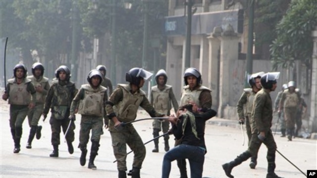 Egyptian army soldiers arrest a woman protester during clashes with military police near Cairo's downtown Tahrir Square,  Egypt Friday, Dec. 16, 2011.