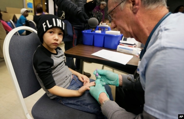 A nurse draws a blood sample from a student at Eisenhower Elementary School in Flint, Michigan, Jan. 26, 2016. Students at the school were being tested for lead after the metal was found in the city's drinking water.