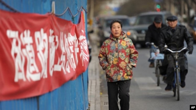 A woman walks outside the housing compound of jailed Chinese dissident Liu Xiaobo, the 2010 Nobel Peace Prize winner, in Beijing, Dec. 8, 2010. Liu is to be honored on Dec. 10 at the Nobel awards ceremony in Oslo.